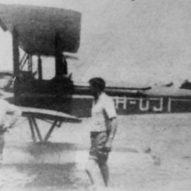 Seaplane at Gunnamatta Bay with two men in the foreground, ca. 1929-1930