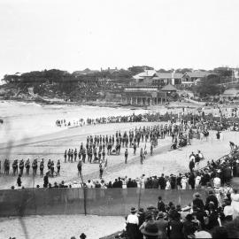 Surf carnival at Cronulla Beach, view of crowds around the beach and lifeguards on the sand, ca. early 1920s