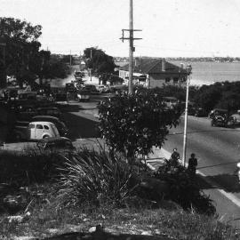 Tom Ugly's Point, view of parked automobiles and cyclist on the road, ca. 1940s