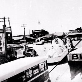 Procession of decorated floats through Cronulla shopping centre, ca. 1930s or 1940s