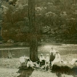 Man, three women and a child under a tree by a river, Royal National Park, ca. 1900s
