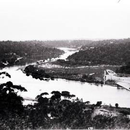 Small plane flying over a river, possibly Woronora River